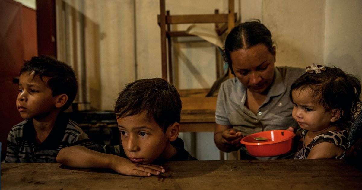 Oriana Caraballo, feeds her children Brayner, 8, Rayman, 6, and Sofia, 22 months, at a soup kitchen in Los Teques, Venezuela.